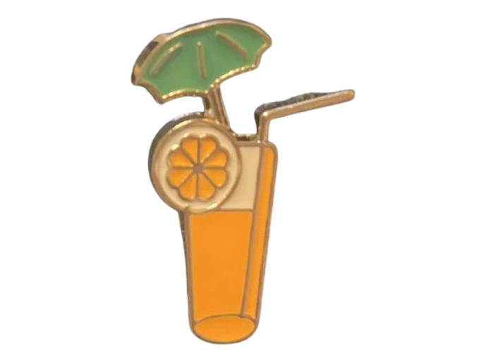 A pin of a glass of orange juice with a cocktail umbrella on it.