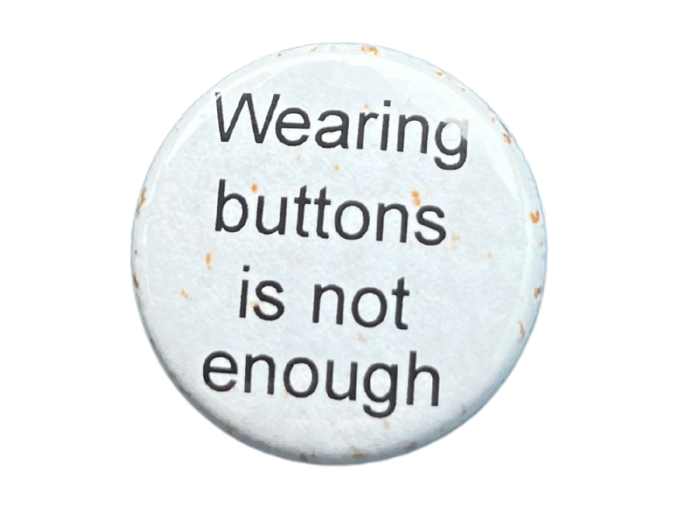 a white button that reads: Wearing buttons is not enough