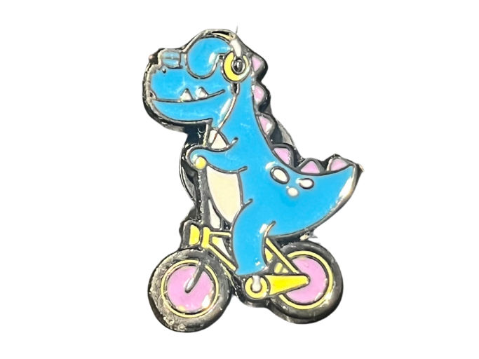 an enamel pin of a blue dinosaur riding a bike.