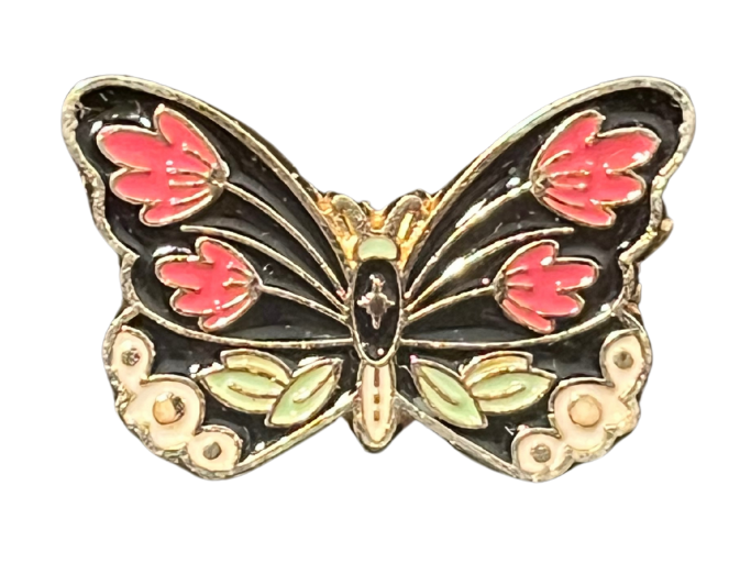 an enamel pin of a black moth with pink flowers on its wings.